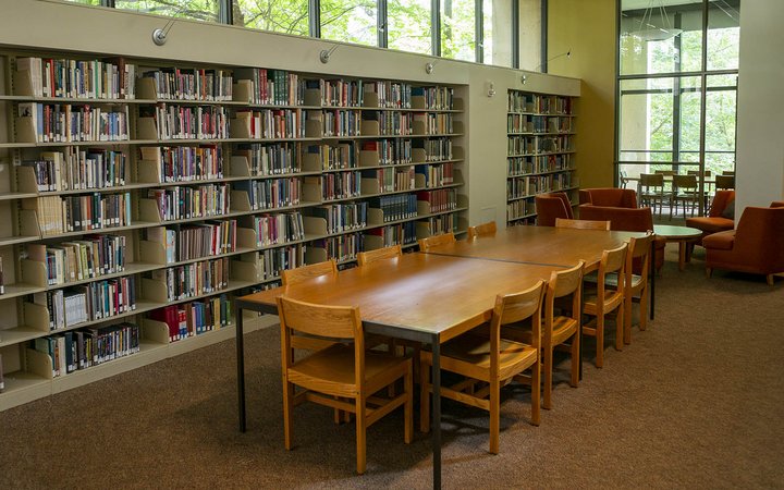 长长的桌子和椅子，旁边放满了书架