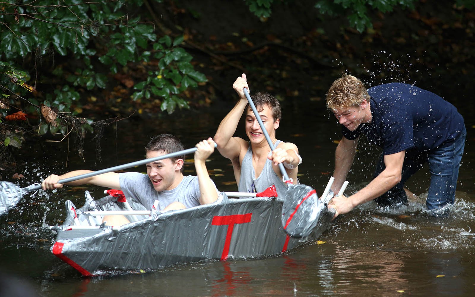 在小溪上划着独木舟的学生