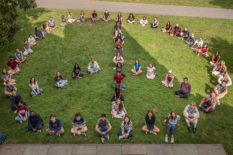 学生坐在草坪上形成巨大的和平标志