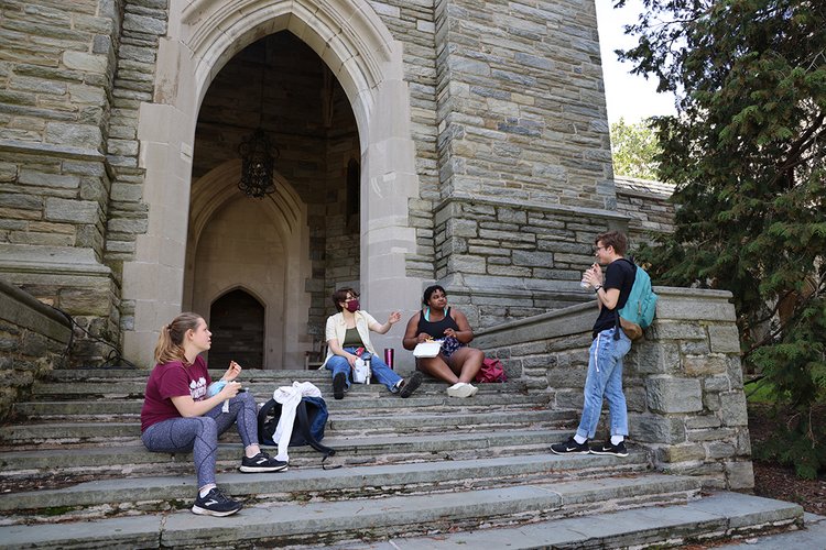 学生们坐在钟楼的台阶上吃午饭