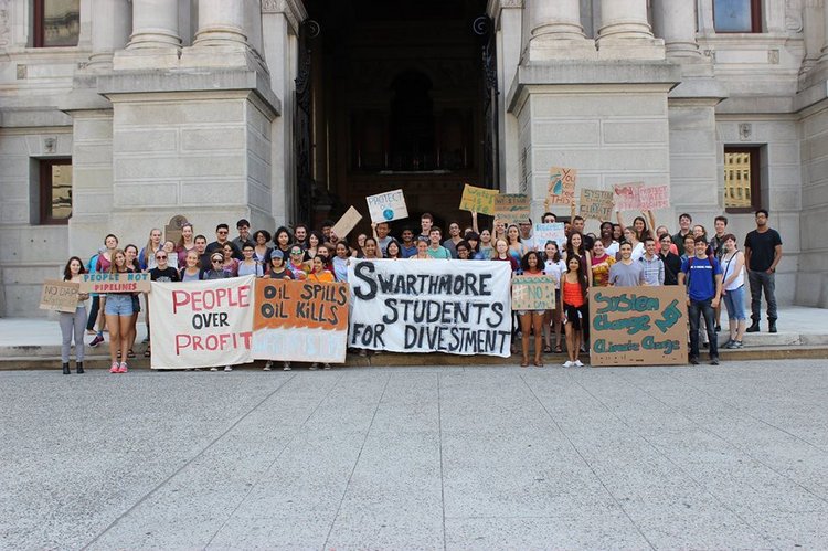 一群顽皮的学生拿着海报最佳线上娱乐呼吁剥离化石燃料