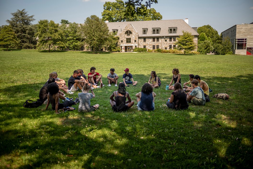 学生坐在户外草坪上圈