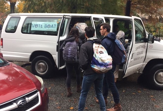 学生进入一辆货车与一个标牌,上面写着“投票船”